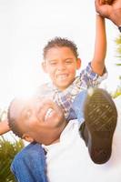 hijo de raza mixta y padre afroamericano jugando juntos al aire libre. foto