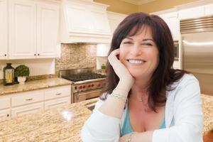 Attractive Middle Aged Woman Portrait Inside Kitchen At Home photo