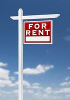 Right Facing For Rent Real Estate Sign on a Blue Sky with Clouds. photo