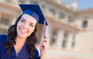 Happy Graduating Mixed Race Woman In Cap and Gown Celebrating on Campus. photo