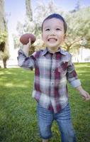 Cute Young Mixed Race Boy Playing Football Outside photo