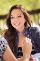 Expressive Young Adult Woman Having Drinks and Talking with Her Friend Outdoors photo