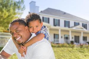 padre afroamericano e hijo de raza mixta, casa detrás foto