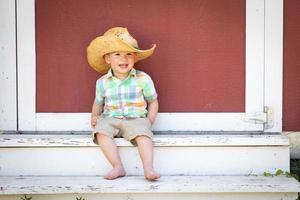 Young Mixed Race Chinese and Caucasian Boy Wearing Cowboy Hat Relaxing On The Steps photo