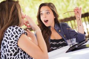 Expressive Young Adult Girlfriends Using Their Computer Electronics Outdoors photo