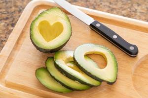 Fresh Cut Avocado With Heart Shaped Pit Area On Wooden Cutting Board photo