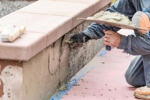 Tile Worker Applying Cement with Trowel at Pool Construction Site photo