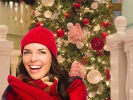 Warmly Dressed Female In Front of Decorated Christmas Tree. photo