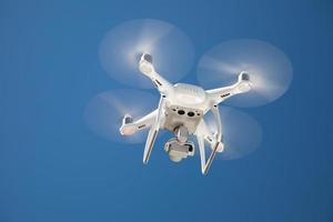 Drone Quadcopter From Below Against A Blue Sky photo