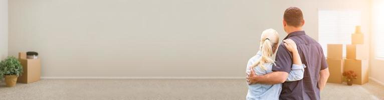 Couple Inside Facing Empty Room with Boxes Banner photo