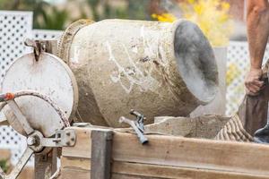 Construciton Worker Mixing Cement At Construction Site photo