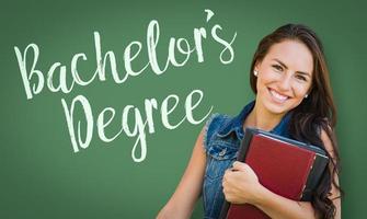 Bachelors Degree Written On Chalk Board Behind Mixed Race Young Girl Student Holding Books photo