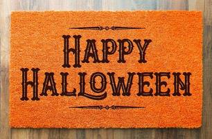 Happy Halloween Orange Welcome Mat On Wood Floor Background photo