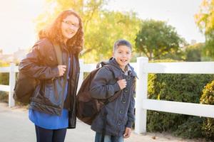 hermano y hermana hispanos con mochilas caminando foto