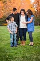 Hispanic Pregnant Family Portrait Against Fall Colored Trees photo