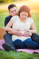 retrato de pareja joven embarazada hispana al aire libre foto