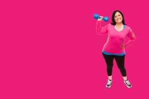 Middle Aged Hispanic Woman In Workout Clothes Holding Dumbbell Against A Bright Magenta Pink Background photo