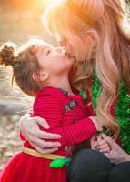 abuela y niña de raza mixta besándose al aire libre foto