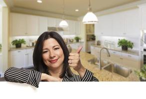 Hispanic Woman With Thumbs Up in Beautiful Custom Kitchen photo