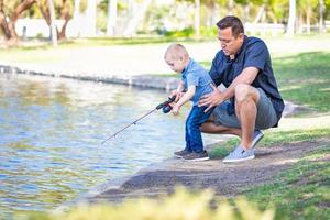 joven caucásico padre e hijo divirtiéndose pescando en el lago foto