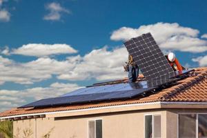 trabajadores instalando paneles solares en el techo de la casa foto