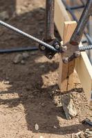 Worker Using Tools To Bend Steel Rebar At Construction Site photo