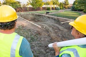 trabajadores masculinos y femeninos con vistas al sitio de construcción de la piscina foto