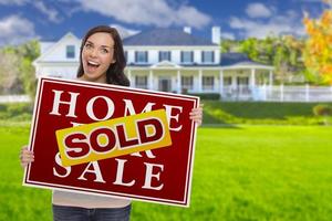 Mixed Race Female with Sold Sign In Front of House photo