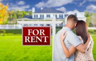For Rent Real Estate Sign, Military Couple Looking at House photo