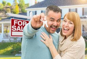 Mixed Race Couple With Keys in Front of Real Estate Sign and New House photo