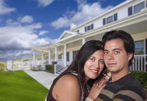 feliz pareja joven hispana frente a su nuevo hogar foto