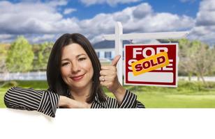 Hispanic Woman in Front of Sold For Sale Sign, House photo