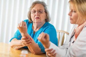 Female Doctor Talking with Senior Adult Woman About Hand Therapy photo