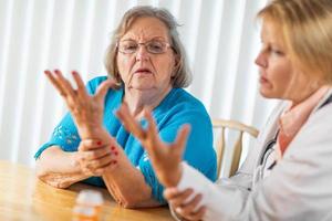 Female Doctor Talking with Senior Adult Woman About Hand Therapy photo