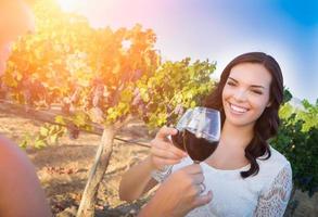 Beautiful Young Adult Woman Enjoying Glass of Wine Tasting Toast In The Vineyard with Friends photo
