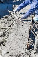 Pool Construction Worker Working With A Smoother Rod On Wet Concrete photo