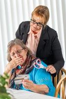 consultor financiero entregando tijeras a una anciana con tarjetas de crédito foto