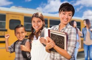 Young Students Walking Near School Bus photo