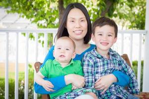 retrato al aire libre de una madre china con sus dos jóvenes chinos y caucásicos de raza mixta foto