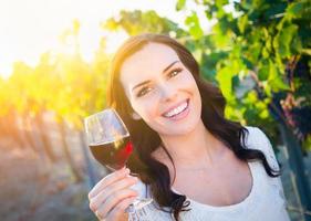 Beautiful Young Adult Woman Enjoying Glass of Wine Tasting In The Vineyard photo
