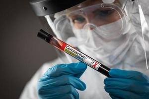 Female Lab Worker Holds Test Tube of Blood Labeled Coronavirus COVID-19 Disease photo