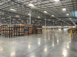 Massive Empty Industrial Warehouse Interior With Stacked Pallets photo