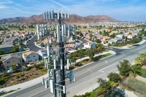 Antena de primer plano de la torre de datos móviles inalámbricos celulares con los alrededores del vecindario foto