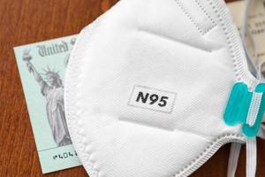 N95 Medical Face Mask Resting On IRS Covid-19 Economic Relief Check photo