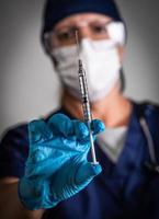 Doctor or Nurse Holding Medical Syringe with Needle photo