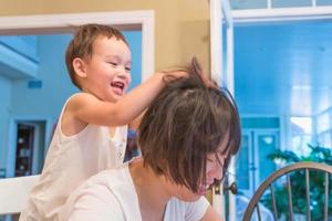 Happy Mixed Race Chinese and Caucasian Boy Having Fun with Chinese Mother Inside House photo