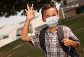 Hispanic Student Boy Wearing Face Mask with Backpack on School Campus photo