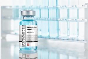 Coronavirus COVID-19 Vaccine Vial Near Test Tubes On Reflective Surface photo