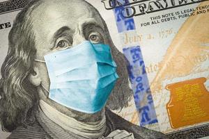 Benjamin Franklin With Worried and Concerned Expression Wearing Medical Face Mask On One Hundred Dollar Bill photo