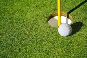 Close-up of Golf Course Green, Flag Pin and Ball. photo